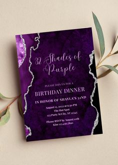 a purple and black birthday party card with silver foil on the front, surrounded by greenery