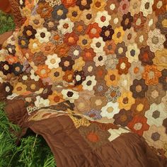 an old quilt is laying on the grass