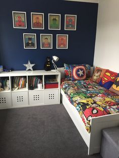 a room with a bed, bookshelf and pictures on the wall above it