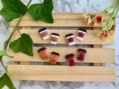 small cupcakes are arranged in the shape of hearts on a wooden board with leaves