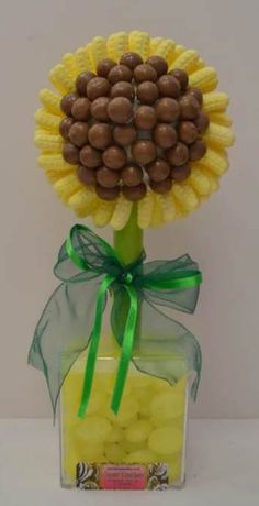 a vase filled with chocolate covered sunflowers and candies on top of a table