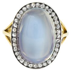 Centering an oval-shaped moonstone cabochon measuring 11.5 x 17.0 mm Translucent colorless body with vivid blue adularescence Prong set in silver with a halo surround of rose cut diamonds Bead set and weighing approximately 0.36 carat total Quality consistent with age - with milgrain detail surround Flanked by tri-split yellow gold shoulders Tested as 18 karat gold and silver Circa: 19th Century; some components dated as recent vintage Ring size: 6 1/2 and sizable Measures north to south 20.5 mm Luxury Vintage Oval Cabochon Moonstone Ring, Antique Gold Moonstone Cabochon Ring, Victorian Yellow Gold Moonstone Cabochon Ring, Luxury Yellow Gold Cabochon Moonstone Ring, Gold Cabochon Moonstone Ring Collectible, Antique Rings Victorian, Journal Jewelry, Silver Tops, Morganite Ring