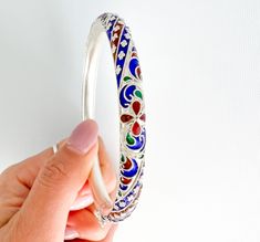 Stunning Fine Silver Jewellery, 999 silver bangle with three colours of enamel    Great Gift I Mom I Wife I Friends I Special Someone I Silver bangle I Silver Bracelet This elegant fine silver bangle features a beautiful handcraft design with a three colours enamel finish, evoking subtle femininity. Colours of enamel: Red, Blue, Green Inside Dia approx: 5.8 cm Silver weight: 27.3g Handmade in a workshop in Northern Thailand Unique style, only one piece each! It comes with a pouch bag and box.  P Elegant Silver Enamel Bangle, Silver Meenakari Bangle Bracelet, Silver Meenakari Bangle, Blue Enamel Bangle As A Gift, Blue Enamel Bangle Perfect As A Gift, Blue Enamel Bangle Gift, Silver Enamel Bracelets For Wedding, Traditional Silver Enamel Bangle, Elegant Multicolor Enamel Bangle