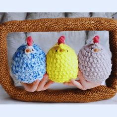 three small crocheted chickens sitting on top of each other