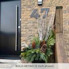 a black door and some plants in front of a brick building with the number 47 on it