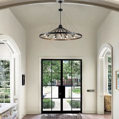 a large foyer with an arched doorway and black glass door leading to the front entrance