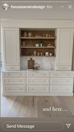 an image of a kitchen with white cabinets and marble counter tops on the phone screen