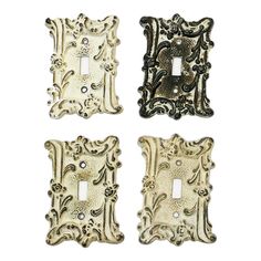 three decorative light switch plates with ornate designs on each one and two toggles