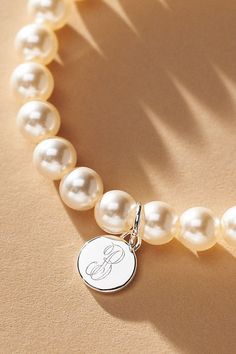 Elevate your special day with the exquisite Pearl Monogram Bracelet, a touch of personalization. Whether you opt for the initial of your cherished partner or choose to commemorate a beloved one, let this bracelet be a timeless symbol of connection and closeness. | Pearl Monogram Pearl Bracelet by Anthropologie in Alphabet, Women's, Gold/Plated Brass/Glass Mother Of The Bride Bracelet, Adjustable White Monogram Jewelry, Elegant White Monogram Jewelry, Classic Initials Bracelet, Perfect As Gift, Elegant Personalized Jewelry With Round Beads, Elegant Personalized Round Bead Jewelry, Classic Charm Bracelet As Gift, Classic White Jewelry With Initials, Classic Personalized Initials Bracelet