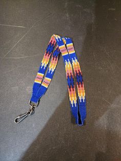 a lanyard with a blue, yellow and red design on the front is sitting on a table