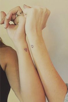 two women with matching tattoos on their arms