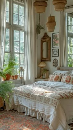 a bed sitting in a bedroom next to two windows with plants on top of it