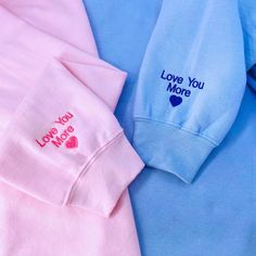 two blue and pink shirts with i love you more embroidered on the chest, next to each other