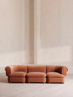 an orange couch sitting on top of a hard wood floor