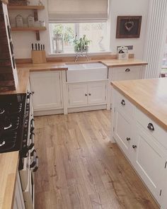 a kitchen with wooden floors and white cabinets