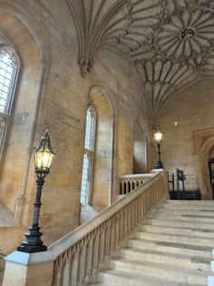 an old building with stone stairs and arched windows on the ceiling, along with a lamp post