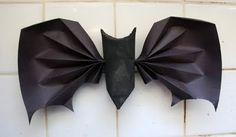 an origami bat hanging on the wall