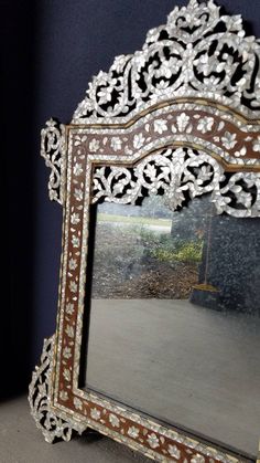 an ornate mirror is sitting on the floor