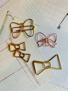 three pairs of bow clips sitting on top of a piece of paper next to scissors