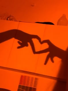 the shadow of a person's hand on a wall in front of a mirror