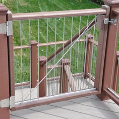 a cat sitting on top of a wooden deck next to a metal railing and fence