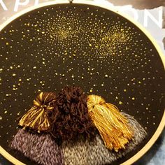 a close up of a plate on a table with gold and black decorations in it