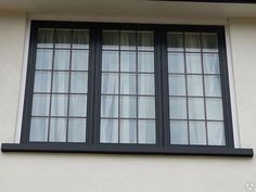 a cat sitting on the ledge of a window