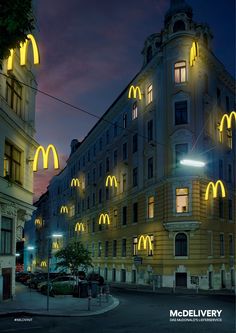 the building is lit up at night with yellow lights on it's windows and arches