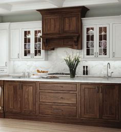 a kitchen with white cabinets and wood floors