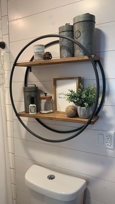 a white toilet sitting next to a wooden shelf with potted plants on top of it