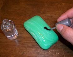 a person is using a toothbrush to brush the top of a small green object