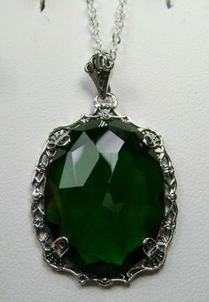 "Simulated Green Emerald Pendant Bubble Design#P10 Custom Made Inspired by Victorian era designs, I now offer this lovely Antique reproduction in sterling silver. The 22ct faceted simulated green emerald gemstone is 24mm long (15/16th\") and 18mm in width (3/4th\"). The entire pendant is 1.5\" long and 7/8\" wide. The chain (if chosen) is between 18-20 inches in length and is marked 925 as well. Notice the beautiful craftsmanship of the Victorian filigree setting. This pendant necklace is a true Silver Emerald Necklace With Intricate Design, Formal Green Engraved Necklace, Green Engraved Jewelry For Anniversary, Engraved Sterling Silver Jewelry For May Birthstone, Emerald Jewelry With Intricate Design For Gift, Elegant Nickel-free Necklace For May Birthstone, Elegant Nickel Free Necklace For May Birthstone, Green Sterling Silver Oval Pendant Jewelry, Silver Oval Pendant With Emerald