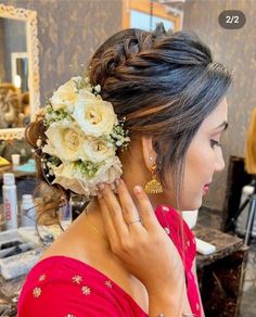 a woman with flowers in her hair getting ready to go into the makeup parlor for her wedding