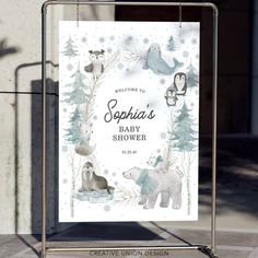 a baby shower sign with animals and snowflakes in the background on a sidewalk