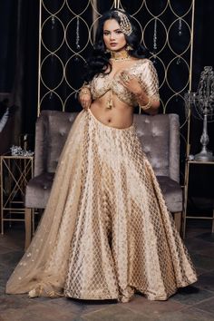 This intricate beauty is such a beautiful array of heritage with a glimpse of a modern day bride! This duo of a radiant Banarsi Silk lehenga and a trendy cut blouse is the perfect go to look for our fashionable divas! #vamadesigns #indianwedding #bollywood #indianbride #lehenga #gold #goldlehenga #punjabiwedding #indianwear#indianfashion #traditionalwear #indianwedding#punjabiwedding #desiwedding #indianbride#bridalwear #bride #sangeet#bridalfashion#bridaloutfit#weddingoutfit #bridal #golden Festive Organza Lehenga For Reception, Navratri Lehenga With Resham Embroidery In Tissue Silk, Floor-length Tissue Silk Lehenga With Sheer Dupatta, Gold Semi-stitched Kundan Lehenga, Festive Embroidered Tissue Silk Lehenga, Reception Lehenga With Pallu In Organza, Anarkali Tissue Silk Lehenga For Reception, Organza Lehenga With Pallu For Reception, Lehenga With Pallu In Organza