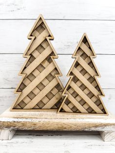 two wooden christmas trees sitting on top of a shelf