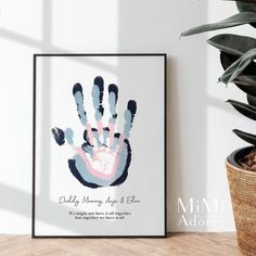 a hand print is hanging on the wall next to a potted plant