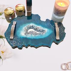 a blue tray with two candles and some other items on the table next to it