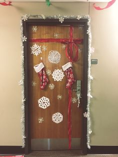 a door decorated with stockings, snowflakes and christmas decorations for the holiday season