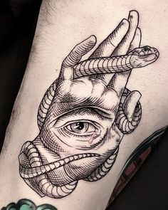 a man's leg with an all seeing eye tattoo on his arm and hand