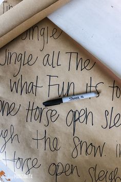 a piece of brown paper with writing on it next to a pen and some scissors