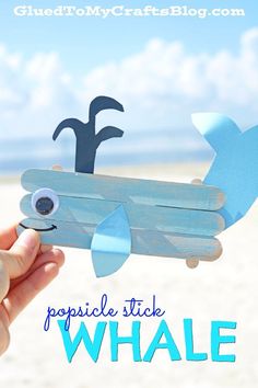 a hand holding up a popsicle stick whale with the words popsicle stick whale on it