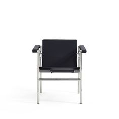 a black leather chair sitting on top of a white floor next to a metal frame