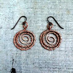 "Spiral Earrings, round dangle earrings, copper wire wrapped, handmade artisan jewelry, fall accessories women, cute birthday gifts for her, Rocky Road Jewelry  Spiral earrings wire wrapped in copper metal wire. Copper is hand formed into spirals and wrapped with copper. Casual, lightweight, everyday wear spiral earrings that go with most every outfit. 1\" diameter spirals, overall length of earrings is 1.25\" dangle, Ear wires are niobium antique copper color, hypo-allergenic. Copper is darkened and polished for a vintage look. Spirals represent our journey through this life artisan jewelry for women and men designed and handcrafted by Rocky Road Jewelry" Wire Wrapped Copper Hoop Earrings, Handmade Copper Wire Wrap Drop Earrings, Handmade Copper Wire Drop Earrings, Copper Wire Wrapped Round Hoop Earrings, Wire Wrapped Spiral Copper Earrings, Copper Wire Earrings For Gifts, Wire Wrapped Copper Spiral Earrings, Copper Spiral Wire Wrapped Earrings, Rose Gold Wire Wrapped Copper Wire Earrings