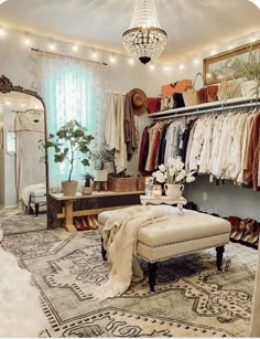 a room filled with lots of clothes and a chandelier