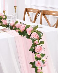 the table is decorated with pink roses and greenery