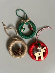 three christmas ornaments hanging from twine on a table