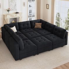 a large black couch sitting on top of a living room floor