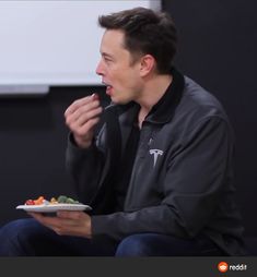 a man sitting down and eating food from a plate in front of him on the screen