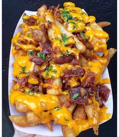 a white plate topped with cheesy fries covered in cheese